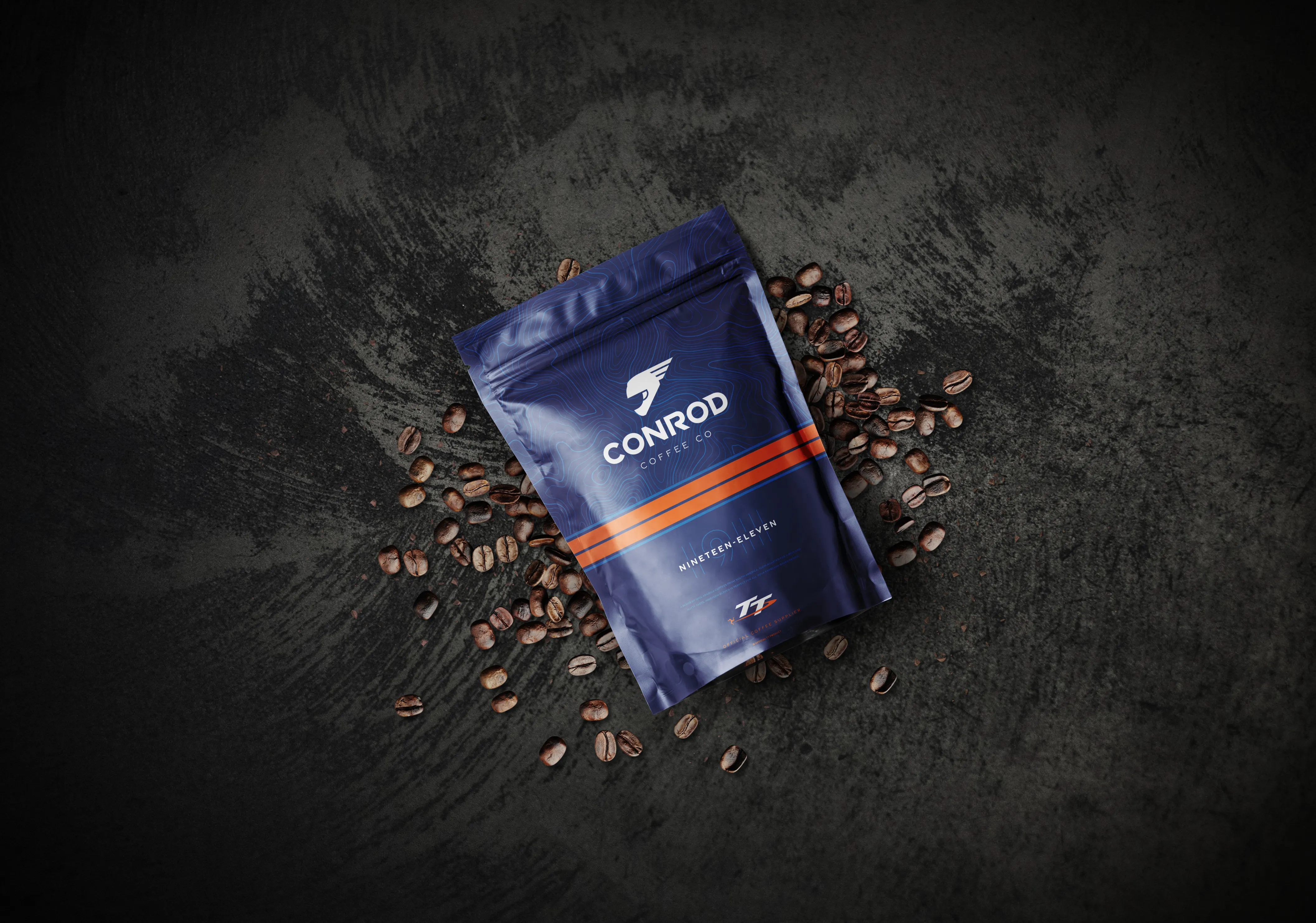 Conrod Coffee Co Nineteen-Eleven blend coffee bag in dark navy surrounded by coffee beans, photographed by DotPerformance for the Conrod Coffee Co website and e-commerce store